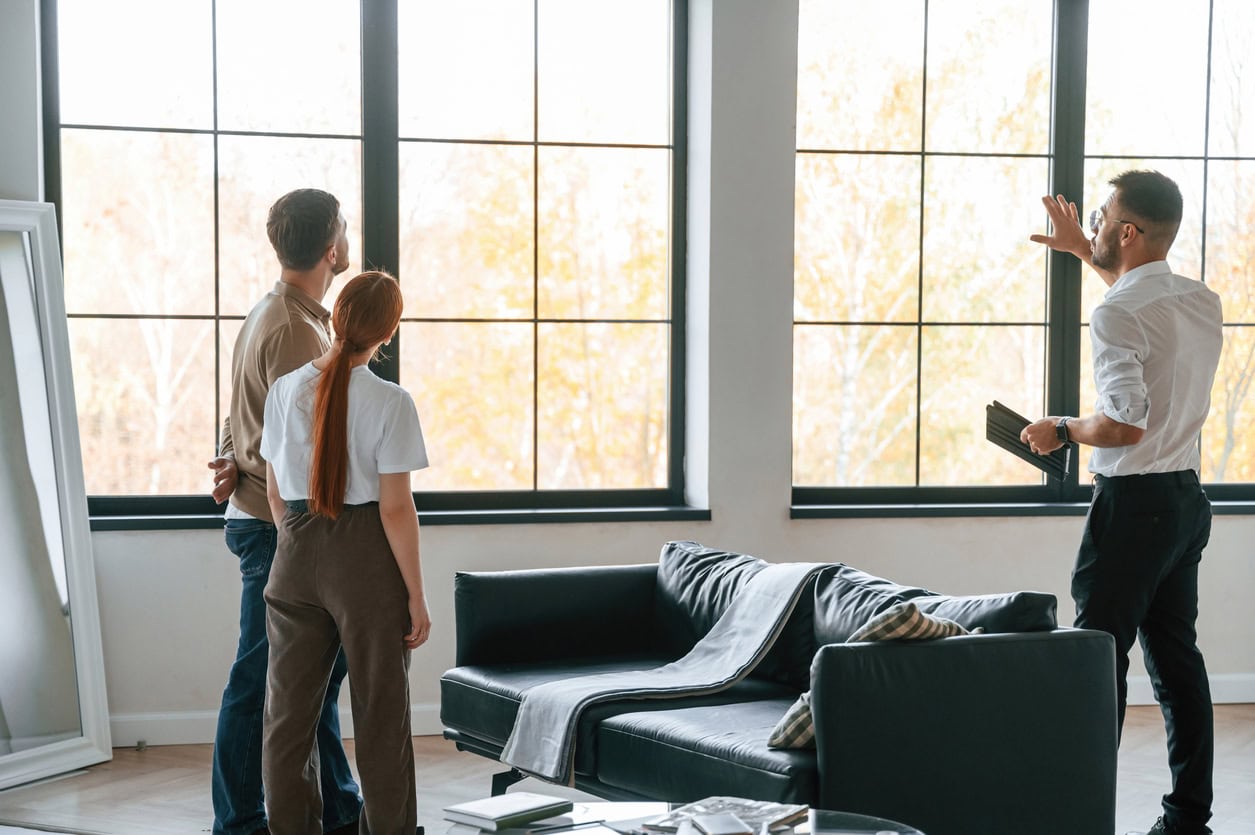 Window and door installation specialist discussing replacement options with homeowners inside their home