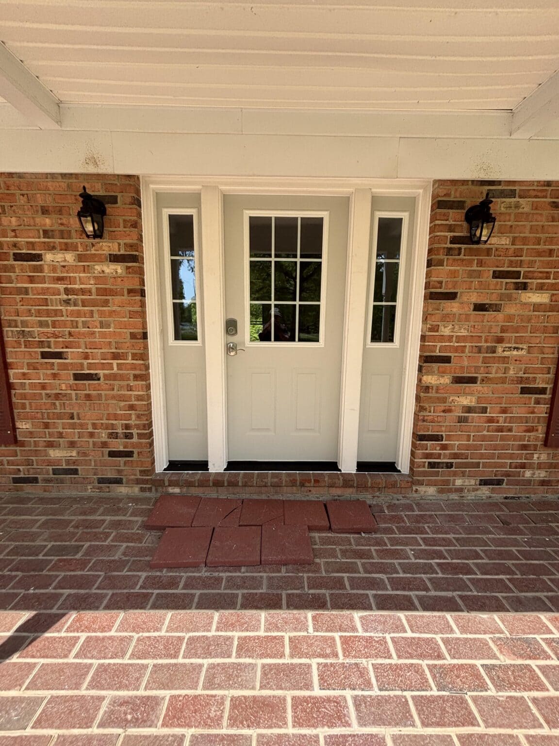White exterior entry door with a glass window panel and silver hardware, featured in a window and door installation project.