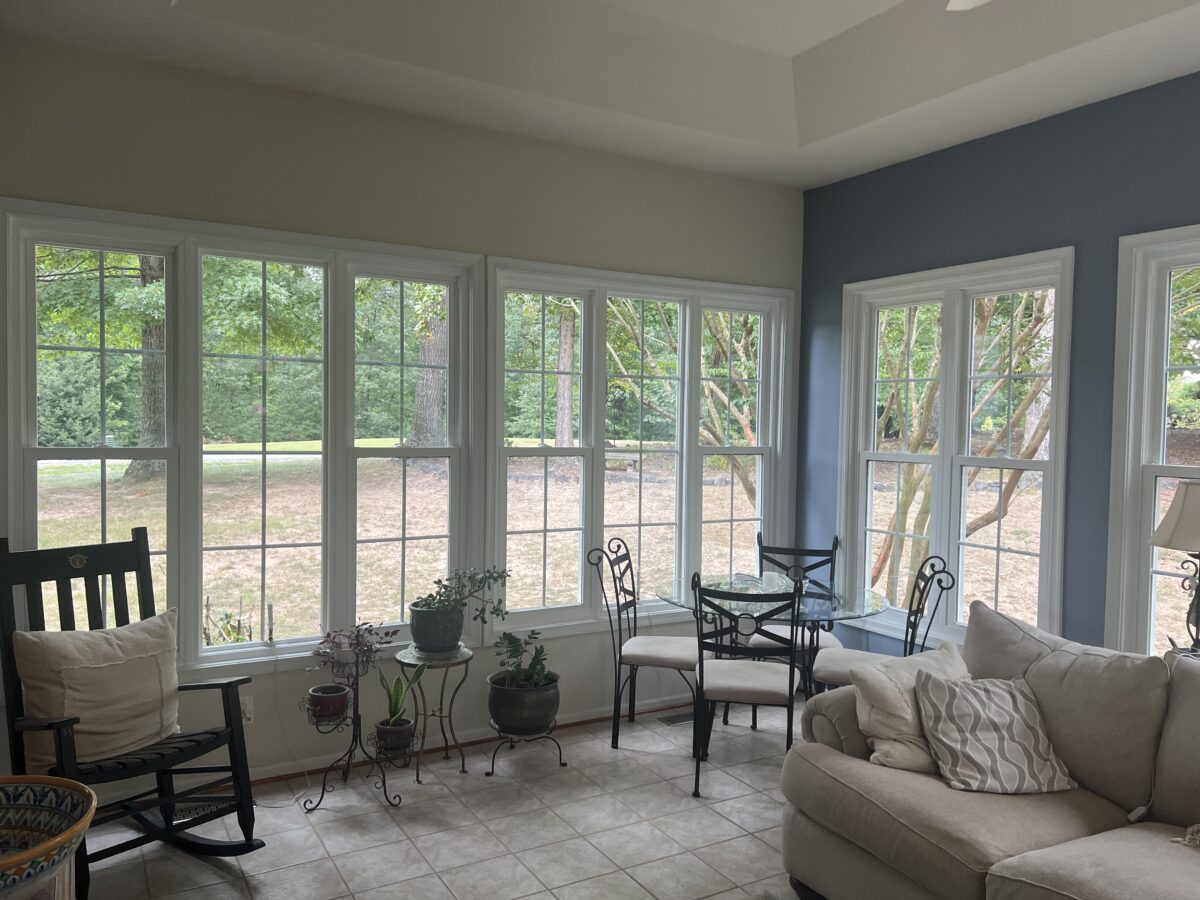 Bright living room with large white-framed windows and glass patio doors.