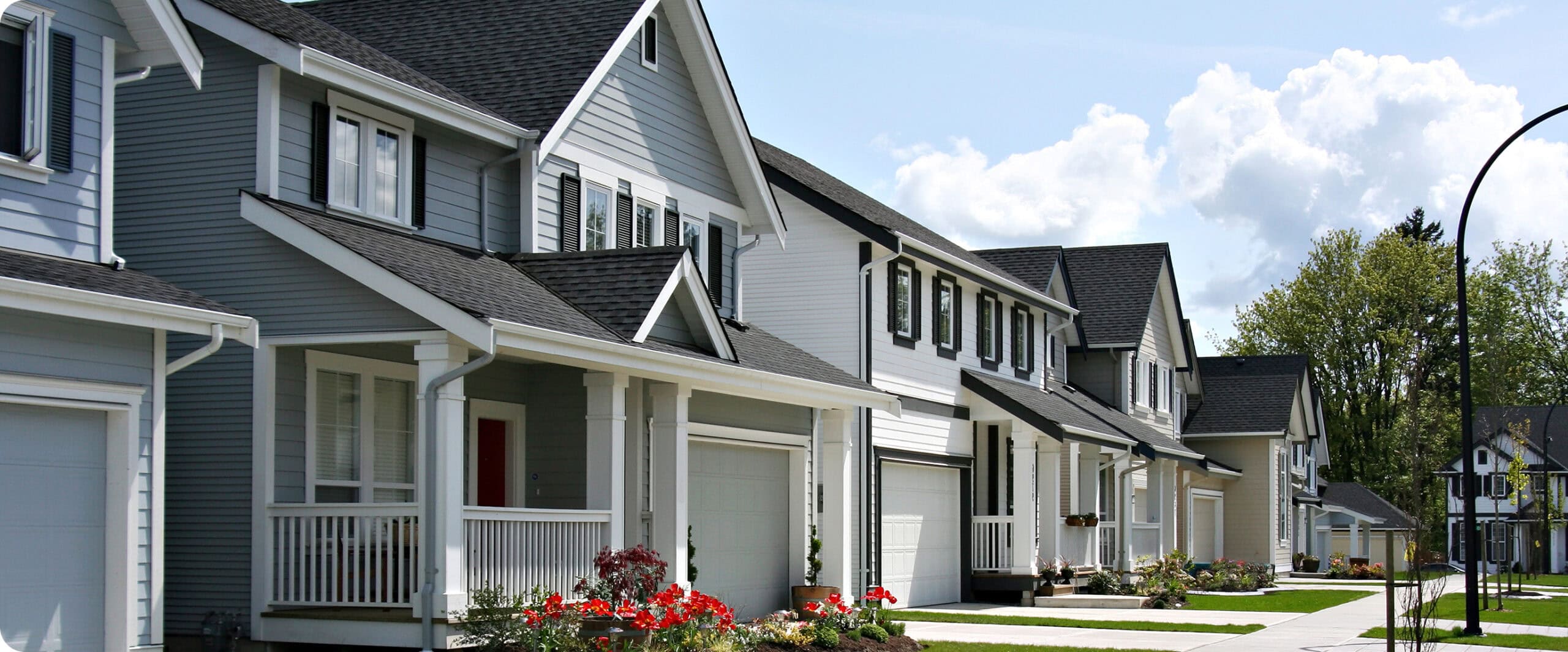Row of residential homes with windows and entry doors showcasing window and door replacement options