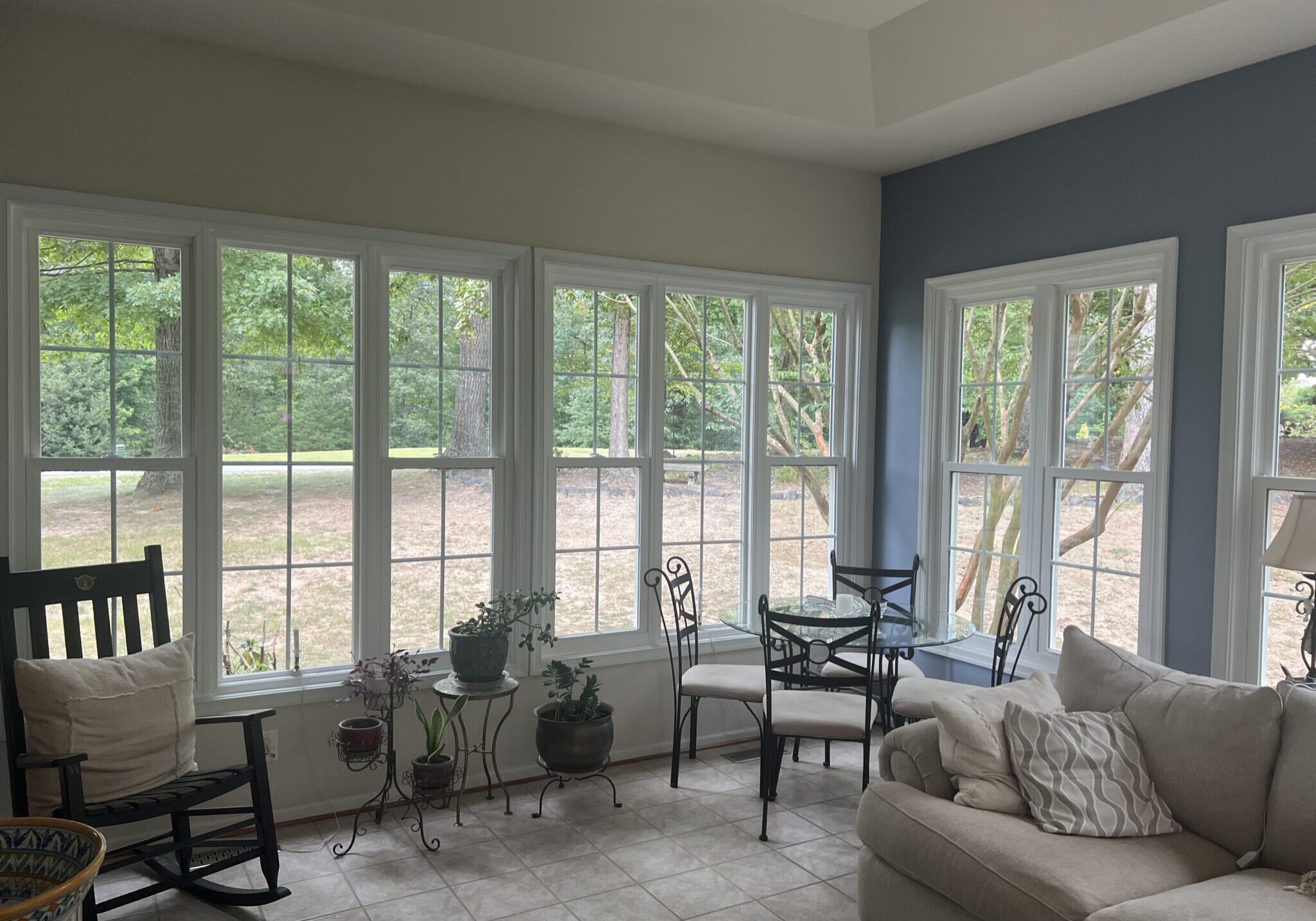 Bright living room with large white-framed windows and glass patio doors.