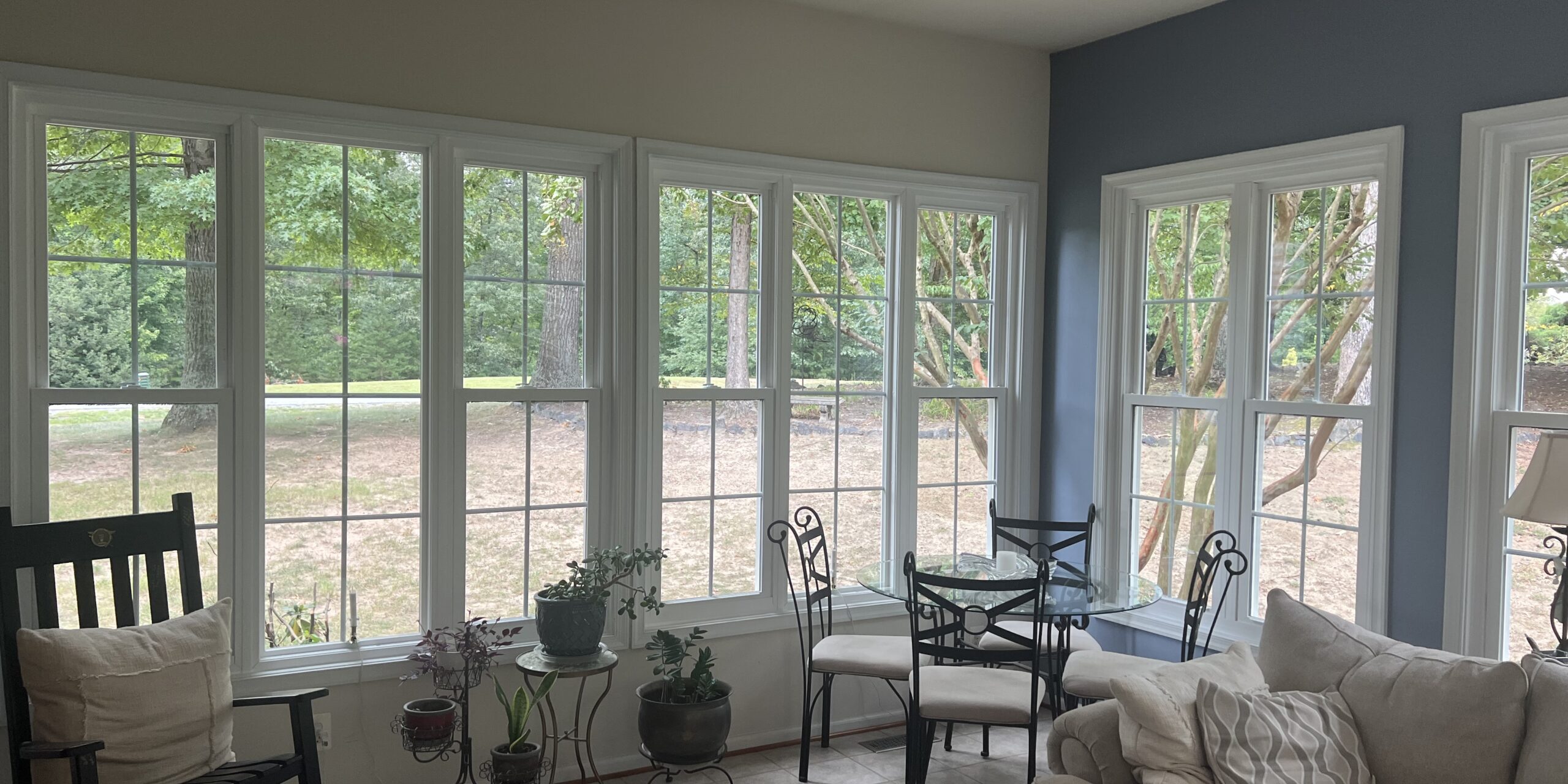 Bright living room with large white-framed windows and glass patio doors.