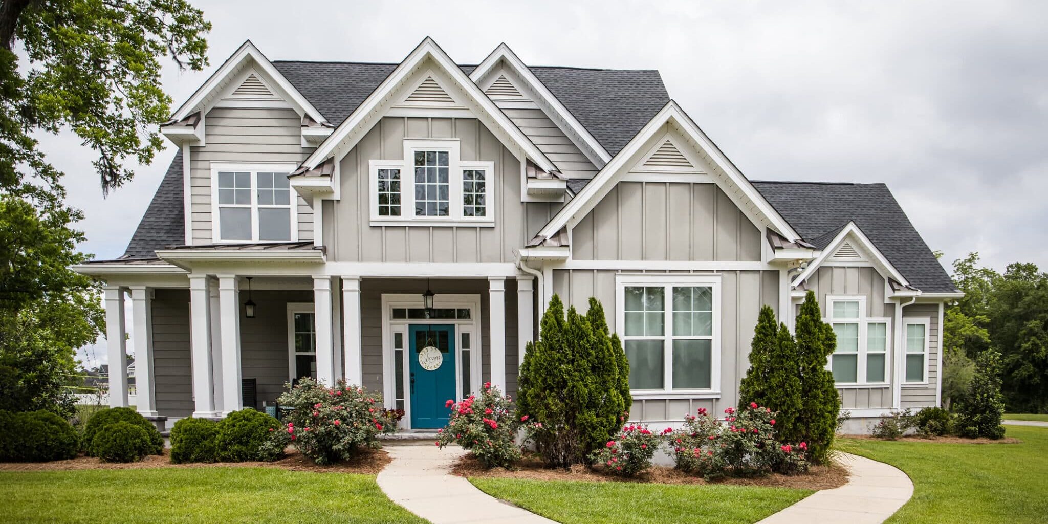This is a single family home that is new construction cottage style house with hardy board and a partial metal roof. It is grey with a teal door and there is great curb appeal. The house has a double front entrance and it is on a large lot.