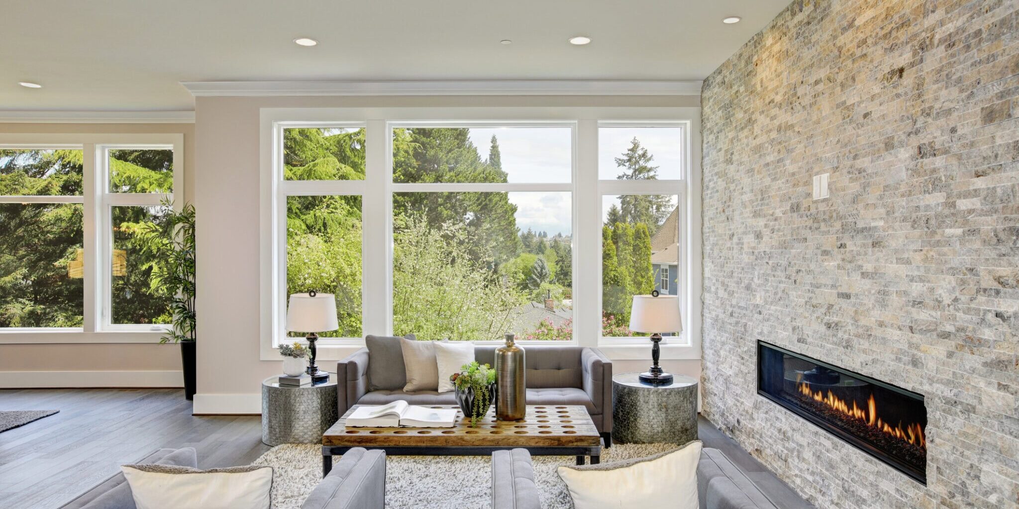 modern living space with flarge glass windows opening to a landscaped